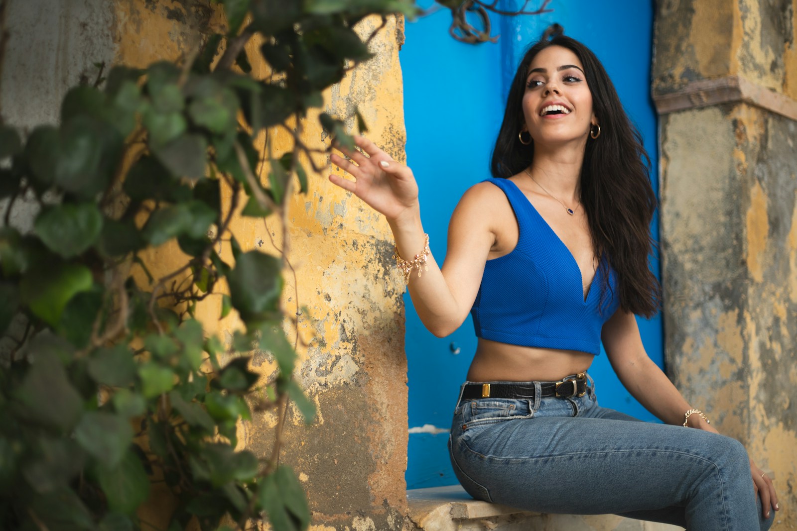Photo by Ines Piazzese woman in blue tank top and blue denim jeans leaning on brown wall