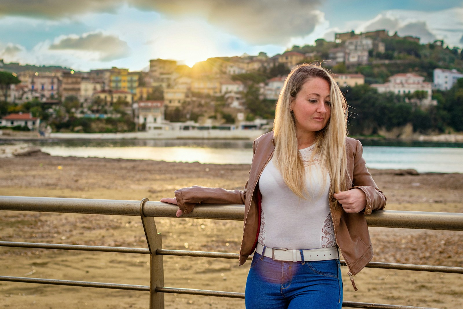 Photo by Erriko Boccia woman leaning on bridge rail in front of buildings